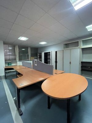 une pièce équipée d'une table, de chaises et d'un réfrigérateur