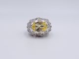 a close up of a yellow diamond ring on a white surface