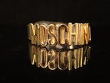 a close up of a gold ring with the word moschchin on it