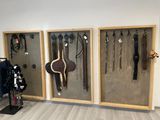 une exposition de harnais et de rênes accrochés au mur