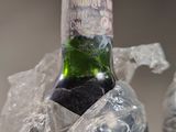 a bottle of wine wrapped in plastic and sitting on a table