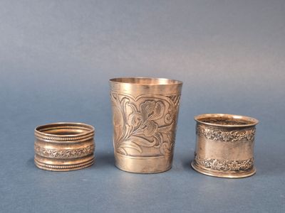 trois tasses en argent posées l'une à côté de l'autre sur une table