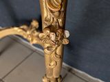a gold table with a marble top on a tile floor