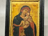 une peinture représentant une femme tenant un bébé dans ses bras