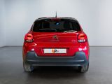 the rear end of a red citrole parked in a white room