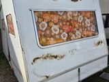 a white trailer with a picture of flowers painted on it