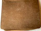 an image of a brown leather wallet sitting on top of a white table