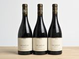 trois bouteilles de vin posées sur une table en bois