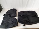 three black bags sitting on top of a white table next to a curtain