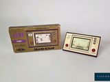 a small electronic game that is sitting next to a box
