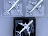 three model airplanes in plastic containers on a table