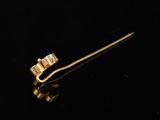 an image of a gold tie bar with a diamond on it