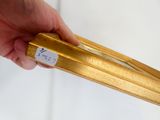 une personne tenant un objet en or sur lequel est collé un autocollant