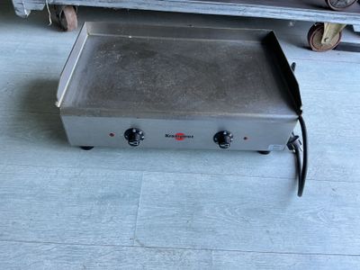 une petite plaque de cuisson électrique posée au sol dans une pièce