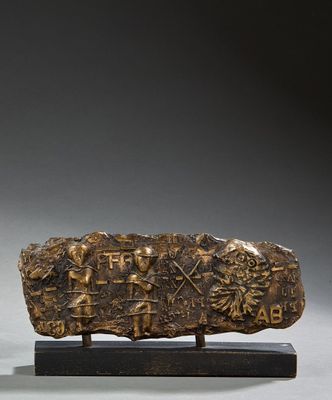 une image représentant une pierre portant une inscription, posée sur un socle en bois