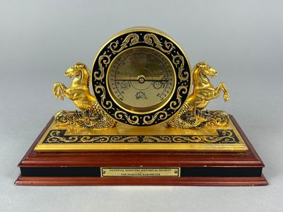 an image of a clock on a wooden base with a clock on top