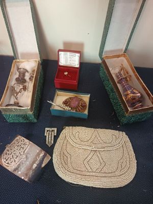 trois boîtes de bijoux posées sur une table, à côté d'un sac à main