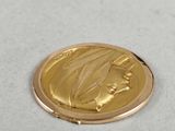 a gold coin with a picture of a woman on it