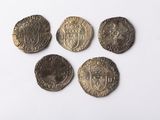 Quatre pièces de monnaie de tailles et de formes différentes sont représentées sur une surface blanche.