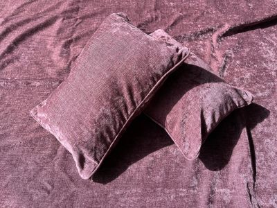 two pillows that are laying on a bed together