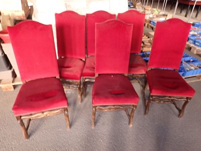 quatre chaises rouges sont alignées en rangée sur le sol