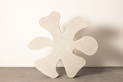 un grand objet blanc posé sur une table devant un mur