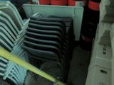 a lot of chairs that are stacked up in a room