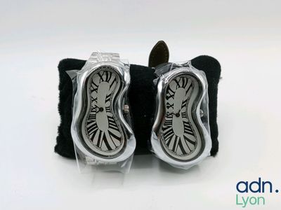 pair of silver and black cuff watches with roman numerals on them