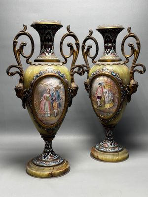 pair of antique vases with painted scenes on them sitting on a table