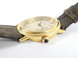 a gold wrist watch with a black leather strap