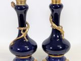 pair of blue and gold vases with a snake on each of them