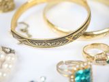 many different types of rings and bracelets on the table