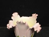 un vase blanc contenant des fleurs roses, sur fond noir