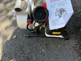 une petite pompe posée par terre à côté d'une borne d'incendie