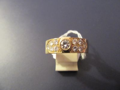 a gold ring with three diamonds on it on a black surface
