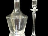 a glass decanter and a wine glass on a black background