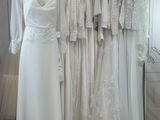 many wedding dresses hanging on a rack in a room