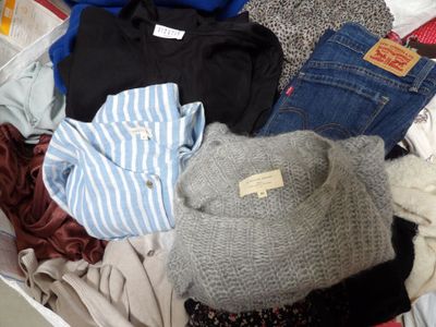 une pile de vêtements posée sur un lit