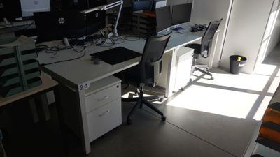 un bureau avec deux ordinateurs et une chaise dans une pièce