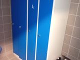 a blue and white bathroom with a toilet and a blue cabinet