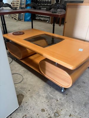 une table en bois avec un plateau en verre dans une pièce