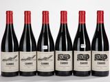six bouteilles de vin rouge sont alignées sur une table