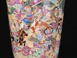 a vase with a painting on it sitting on a table