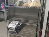 une étagère métallique sur laquelle sont posés des aliments, dans une cuisine