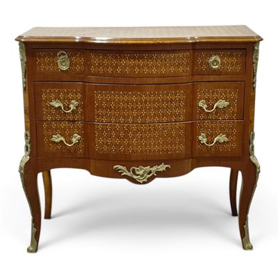 an antique chest of drawers with ornate carvings and brass handles