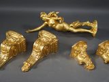 quatre figurines en or représentant des chérubins et des anges sur un fond gris