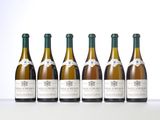 six bottles of wine are lined up in a row on a table