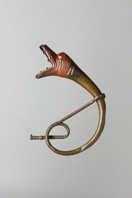 a metal sculpture of a horn on a stand