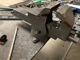 a vise that is sitting on a workbench in a workshop