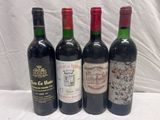 four bottles of wine are lined up on a white surface